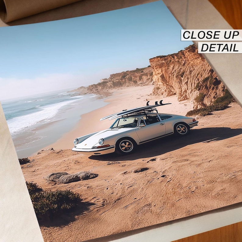 May include: A silver vintage car with surfboards on the roof parked on a sandy beach. The car is facing the ocean with a clear blue sky in the background. The words "CLOSE UP DETAIL" are in the upper right corner.