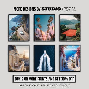 May include: Six framed art prints featuring scenic landscapes. The prints showcase a coastal road, palm trees, a tennis court, a Parisian balcony, a boat on the water, and a Mediterranean village. Text reads "MORE DESIGNS BY STUDIO VISTAL".