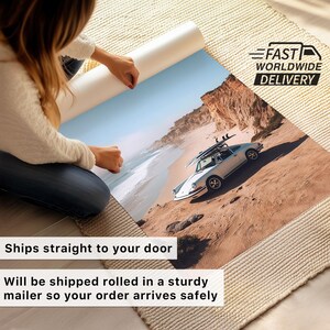 May include: A rolled print of a coastal scene featuring a white vintage car with surfboards parked on a sandy hillside. The print is being unrolled, revealing a beach and ocean under a blue sky. The text "Ships straight to your door" is visible.
