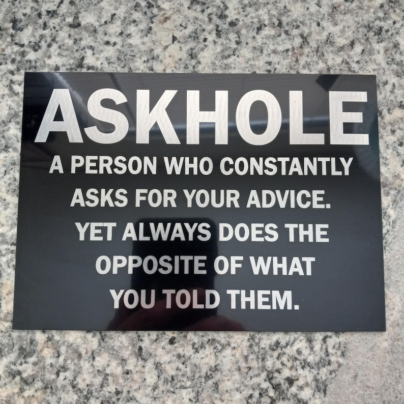 May include: A black sign with white text that reads "ASKHOLE A PERSON WHO CONSTANTLY ASKS FOR YOUR ADVICE. YET ALWAYS DOES THE OPPOSITE OF WHAT YOU TOLD THEM."