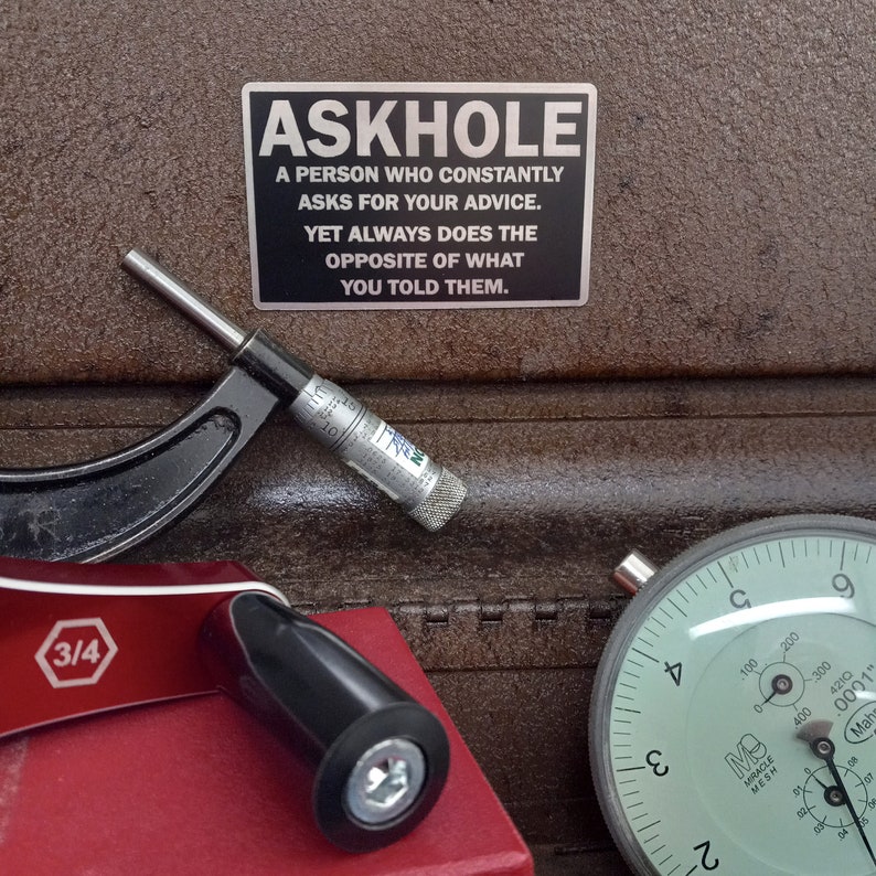 May include: A silver metal sign with black text that reads "ASKHOLE A PERSON WHO CONSTANTLY ASKS FOR YOUR ADVICE. YET ALWAYS DOES THE OPPOSITE OF WHAT YOU TOLD THEM."