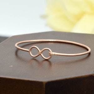 Op de afbeelding: Een roségouden armband met een oneindigheidssymbool. De armband is dun en delicaat, met een eenvoudig ontwerp.
