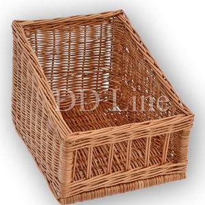 Op de afbeelding: Een natuurlijke geweven rieten mand met een rechthoekige vorm en een licht hellende voorkant. De mand heeft een natuurlijke bruine kleur en is gemaakt van geweven riet.