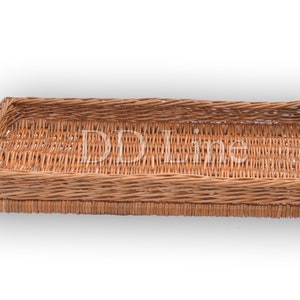 Op de afbeelding: Een rechthoekige geweven rieten mand met een dubbele rand. De mand is gemaakt van natuurlijke bruine riet.