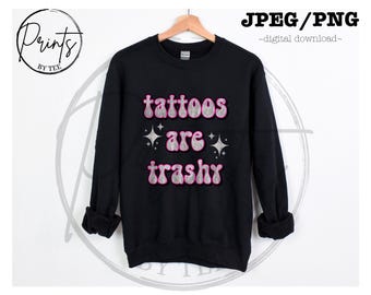 May include: Black sweatshirt with the text "tattoos are trashy" in pink and silver glitter lettering.