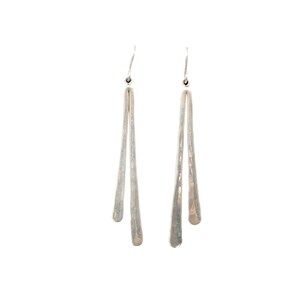 Pu&ograve; includere: Un paio di orecchini pendenti color argento. Ogni orecchino presenta un lungo design sottile a forma di goccia. Gli orecchini hanno uno stile semplice ed elegante, perfetto per l'uso quotidiano o per occasioni speciali.