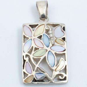 May include: A silver pendant with a rectangular frame featuring a delicate floral design. The frame is filled with colorful mother-of-pearl inlay, creating a vibrant and intricate pattern.