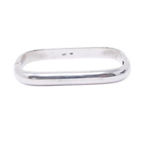 May include: A polished silver-tone metal bangle bracelet with a rectangular shape and rounded corners. The bracelet features a hinged opening mechanism on one side and a smooth, reflective surface throughout its entire continuous band design.