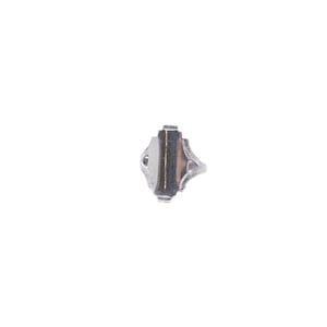 Può includere: Un anello color argento con una pietra rettangolare verticale di colore marrone scuro al centro. La fascia in metallo presenta intricate incisioni decorative su entrambi i lati dell'incastonatura, creando un aspetto dettagliato e strutturato.