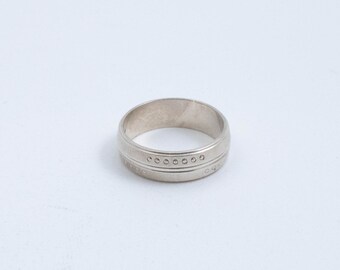 Può includere: Una fede nuziale in argento con un design testurizzato e una fila di piccoli punti.
