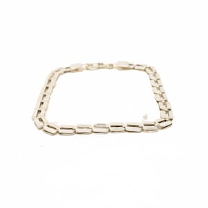 May include: A silver-colored bracelet with a rectangular link design. The bracelet is laid flat against a white background, showcasing its geometric pattern and metallic sheen. The links are evenly spaced, creating a continuous chain.