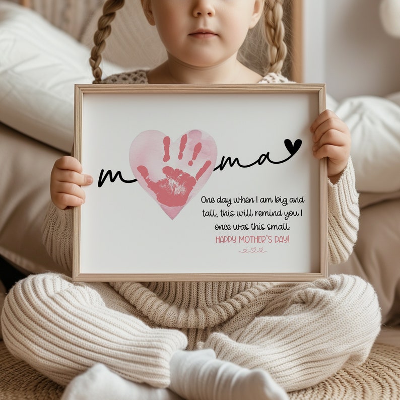 Peut inclure: Une impression encadr&eacute;e avec une empreinte de main rose en forme de c&oelig;ur. L'impression dit "m  ma" et "Un jour, quand je serai grand et grand, cela te rappellera que j'&eacute;tais autrefois si petit. Joyeuse f&ecirc;te des m&egrave;res !"