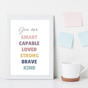 May include: White framed print with the text "You are SMART CAPABLE LOVED STRONG BRAVE KIND" in colorful text.
