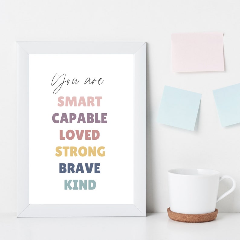 May include: White framed print with the text "You are SMART CAPABLE LOVED STRONG BRAVE KIND" in colorful text.