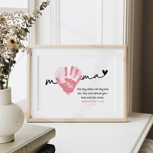 Peut inclure: Une empreinte de main rose en forme de c&oelig;ur avec le mot "mama" &eacute;crit en cursive noire au-dessus. Le texte ci-dessous indique "Un jour, quand je serai grand et grand, cela vous rappellera que j'&eacute;tais autrefois si petit. Joyeuse f&ecirc;te des m&egrave;res !"