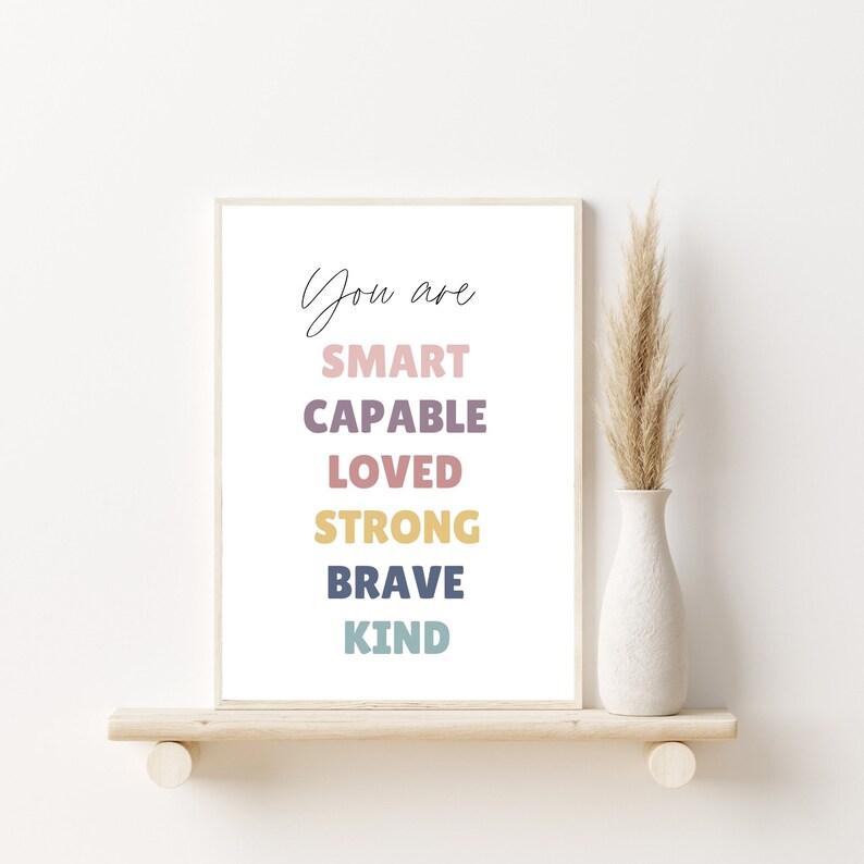May include: A white framed print with the text "You are SMART CAPABLE LOVED STRONG BRAVE KIND" in colorful letters.