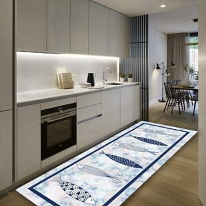 May include: A blue and white patterned kitchen rug with a marble design and a border of dark blue. The rug features a design of stylized fish with white scales and black outlines.
