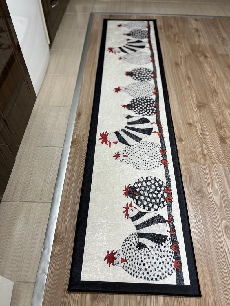 May include: A black and white runner rug with a black border features a line of black and white chickens with red combs. The chickens are all facing the right side of the rug.