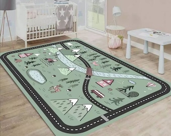 May include: A green and black playmat with a road, mountains, trees, and animals. The playmat is designed for children to play on and features a variety of fun elements.