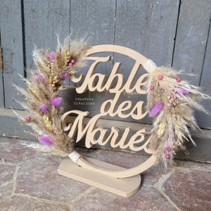 Centrotavola nuziale in legno e fiori secchi in pampas viola e marrone per una decorazione nuziale