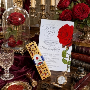 Peut inclure: Une carte d'invitation blanche avec le texte noir Be Our Guest et Quinceañera Honoring Giver Engleking, ornée d'une rose rouge. À côté se trouvent une cloche en verre avec une rose, une boîte dorée découpée au laser et une montre à gousset.