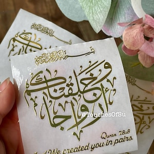 May include: Gold foil sticker with Arabic calligraphy and the text "And We created you in pairs."  Quran 78:8.  The sticker is on a white background.