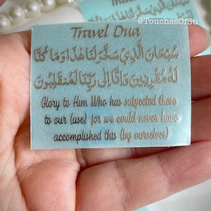 May include: A light blue card with gold lettering that reads "Travel Dua" and includes an Islamic prayer in Arabic script. The text translates to "Glory to Him Who has subjected these to our (use) for we could never have accomplished this (by ourselves)".