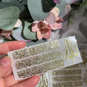 May include: Gold foil stickers with Arabic calligraphy and the word "Allah" in gold foil. The stickers are on a white background.