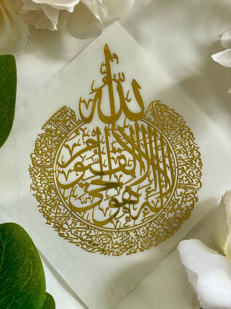 May include: A gold-colored sticker with the Arabic word "Allah" in a decorative font surrounded by a circle of smaller Arabic script.