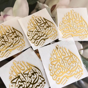May include: Five gold foil stickers with Arabic calligraphy on a white background. The calligraphy says "Allah" in Arabic.