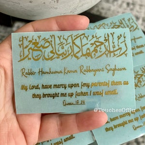 May include: A blue sticker with gold Arabic calligraphy and the text "Rabber Hamhuma Kama Rabbayani Sagheera" which translates to "My Lord, have mercy upon (my parents) them as they brought me up when I was small." The sticker also includes the reference "Quran 17:24".