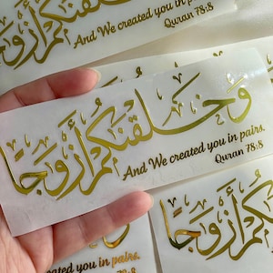 May include: Gold vinyl sticker with Arabic calligraphy and the text "And We created you in pairs. Quran 78:8".
