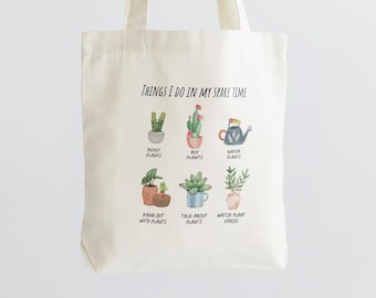 May include: A white tote bag with the text "THINGS I DO IN MY SPARE TIME" and illustrations of plants in pots. The text below the illustrations includes phrases like "Repot Plants", "Buy Plants", "Water Plants", "Hang Out With Plants", "Talk About Plants", and "Watch Plant Videos".