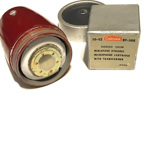 May include: A maroon microphone with a visible internal metallic component, a circular silver speaker grille, and a square silver box labeled 10-42 Calrad DT-50K 50000 OHM MINIATURE DYNAMIC MICROPHONE CARTRIDGE WITH TRANSFORMER JAPAN.