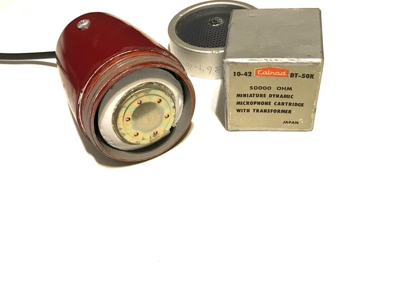 May include: A maroon microphone with a visible internal metallic component, a circular silver speaker grille, and a square silver box labeled 10-42 Calrad DT-50K 50000 OHM MINIATURE DYNAMIC MICROPHONE CARTRIDGE WITH TRANSFORMER JAPAN.