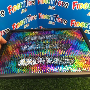 May include: A square picture with a rainbow sequin design, framed in black. The sequins can be flipped to reveal a different colour.
