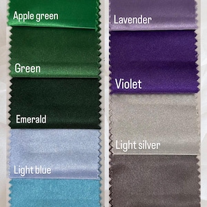 May include: A color swatch image featuring samples of fabric in various colors. The swatches include shades of green, blue, purple, silver, and black. Each swatch is labeled with its corresponding color name, such as "Apple green," "Lavender," and "Silver."