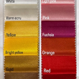 May include: A color swatch image featuring samples of fabric in various colors. The left side displays shades like white, warm ecru, yellow, bright yellow, gold, camel, and brown. The right side shows light pink, pink, fuchsia, orange, red, cherry, and burgundy.