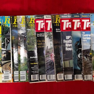 May include: A collection of Trains magazines arranged in a row, featuring various locomotive photography on the covers. The visible text includes titles like Trains, The Magazine of Railroading, and headlines such as Chicago & Eastern Illinois: Worthy of recall.