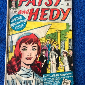 Può includere: Una copertina di fumetto vintage con Patsy e Hedy, due giovani donne in abiti da laurea. La copertina è gialla con testo rosso e bianco. Il testo recita "Patsy e Hedy" e "Numero speciale di laurea!" Il fumetto è di Marvel Comics Group e risale all'agosto 1959.