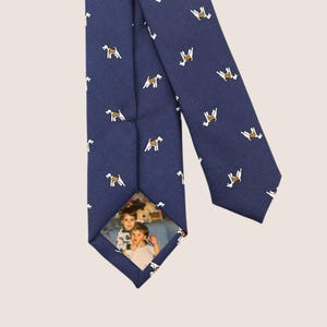 May include: Navy blue tie with a repeating pattern of small white and brown dog illustrations. The tie features a custom photo of two children on the back of the tie.