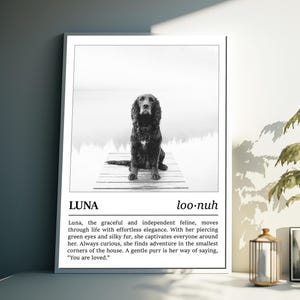 May include: Black and white photo of a dog named Luna sitting on a wooden dock. The photo is framed with a white border and includes a definition of the name Luna, which is "loo-nuh". The definition reads: "Luna, the graceful and independent feline, moves through life with effortless elegance. With her piercing green eyes and silky fur, she captivates everyone around her. Always curious, she finds adventure in the smallest corners of the house. A gentle purr is her way of saying, "You are loved."