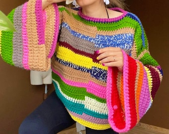 Puede incluir: Un suéter de crochet a rayas de colores con mangas acampanadas. El suéter está hecho con una variedad de colores, incluyendo rosa, verde, amarillo, azul y marrón.