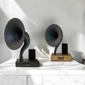 May include: Two vintage-style gramophone speakers with black and brown finishes. Each speaker has a black phone stand and a wooden base with the text "The Gramophone" on it.