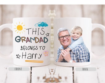 May include: White ceramic mug with a colorful design that says "This Granddad belongs to Harry" and a photo of a man and a young boy on the back.