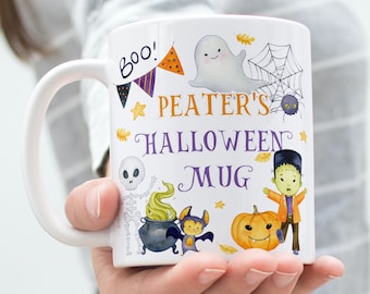Könnte beinhalten: Weiße Keramiktasse mit Halloween-Motiv. Sie zeigt ein Gespenst, ein Spinnennetz, ein Skelett, einen Kessel, eine Fledermaus, einen Kürbis und einen Frankenstein. Der Text auf der Tasse lautet "Boo! Peater's Halloween Mug".