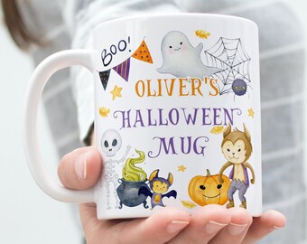 Könnte beinhalten: Eine weiße Keramiktasse mit Halloween-Motiv. Sie zeigt ein Gespenst, ein Spinnennetz, ein Skelett, einen Kessel, eine Fledermaus, einen Werwolf und einen Kürbis. Auf der Tasse steht "Oliver's Halloween Mug" in lila Schrift.