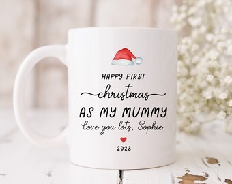 May include: White ceramic mug with a red Santa hat illustration and the text "Happy First Christmas as my Mummy love you lots, Sophie 2023".