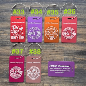 May include: Eight colorful luggage tags with different designs and text. The tags are numbered 33 through 38. The text on the tags includes "Oh Sip! It's a Girl's Trip", "Girl's Trip", "Vacay Vibes with my Tribe", "Warning Girls Trip in Progress", "What Happens on Girls Trip Stays on Girls Trip", "Jamaica Girls Trip Making Memories Together", and "Jordan Stevenson 14832 Sherwoon St, Buffalo, NY JordanStevenson@gmail.com 555-555-5555".