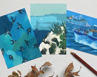 May include: Three watercolor paintings on white cardstock. The first painting features a blue and green abstract design with black birds flying. The second painting features a blue and green landscape with a white cliff and green plants. The third painting features a blue boat with people on it sailing on blue water.